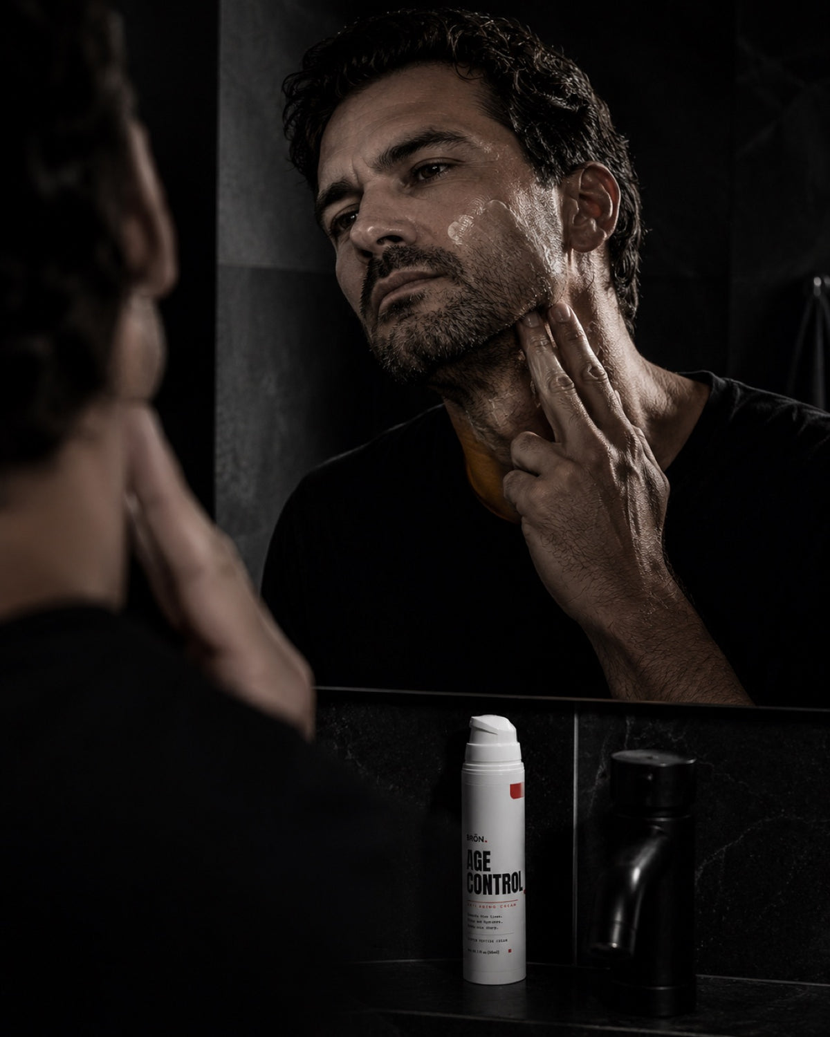 Man massaging cream into his face and neck