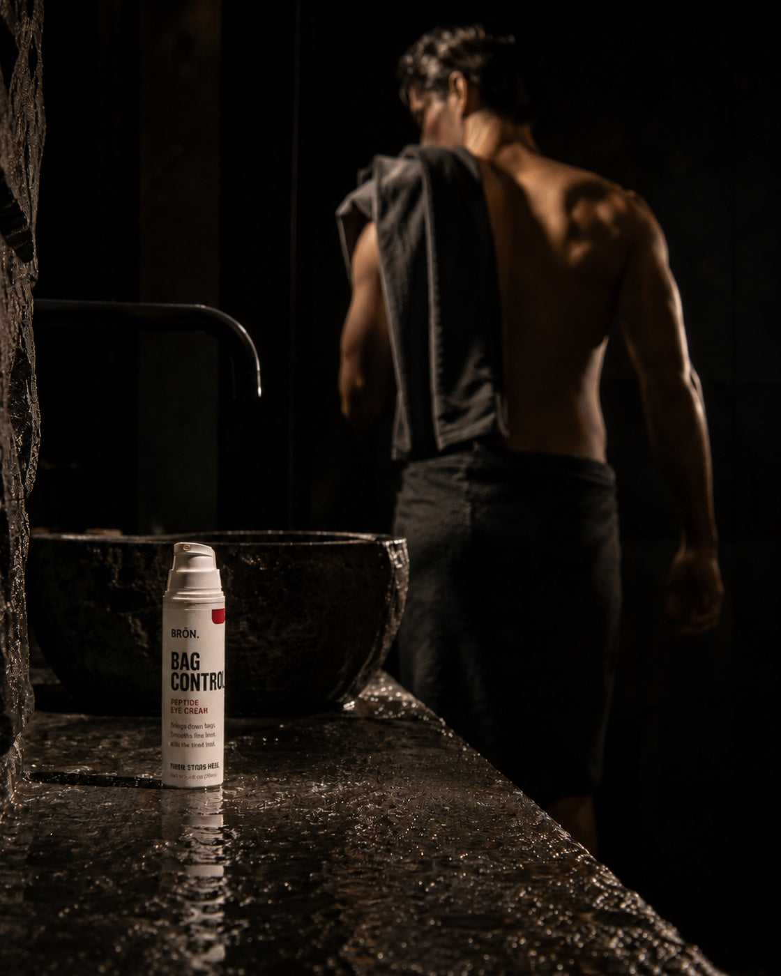 Man leaving the bathroom, bottle on the counter