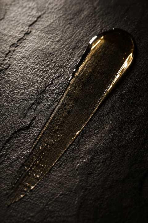 Golden serum swipe on dark slate