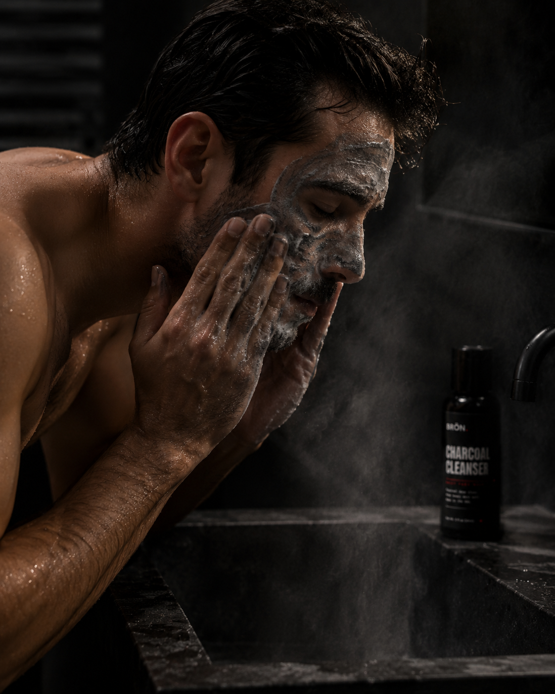 Man working charcoal lather across his face